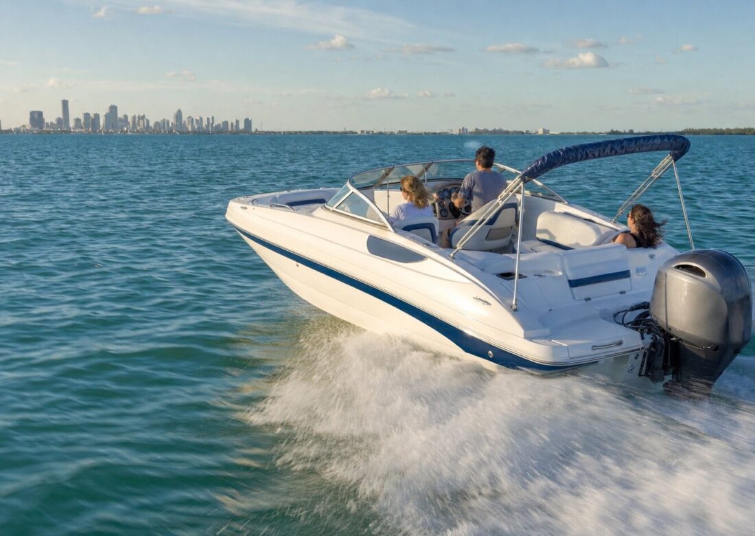 Hurricane SunDeck 2200 deck boat underway on Biscayne Bay with the Miami skyline behind